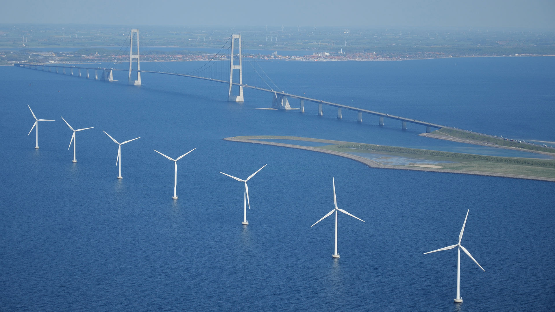 Picture of wind turbines lined up at Storebæltsbroen in Denmark.